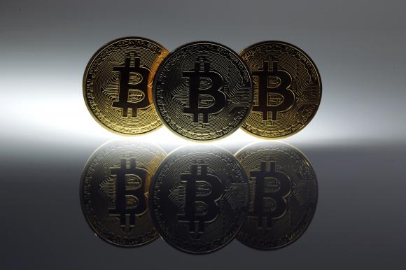 Mock Bitcoins are displayed on a table in an illustration picture taken in Berlin